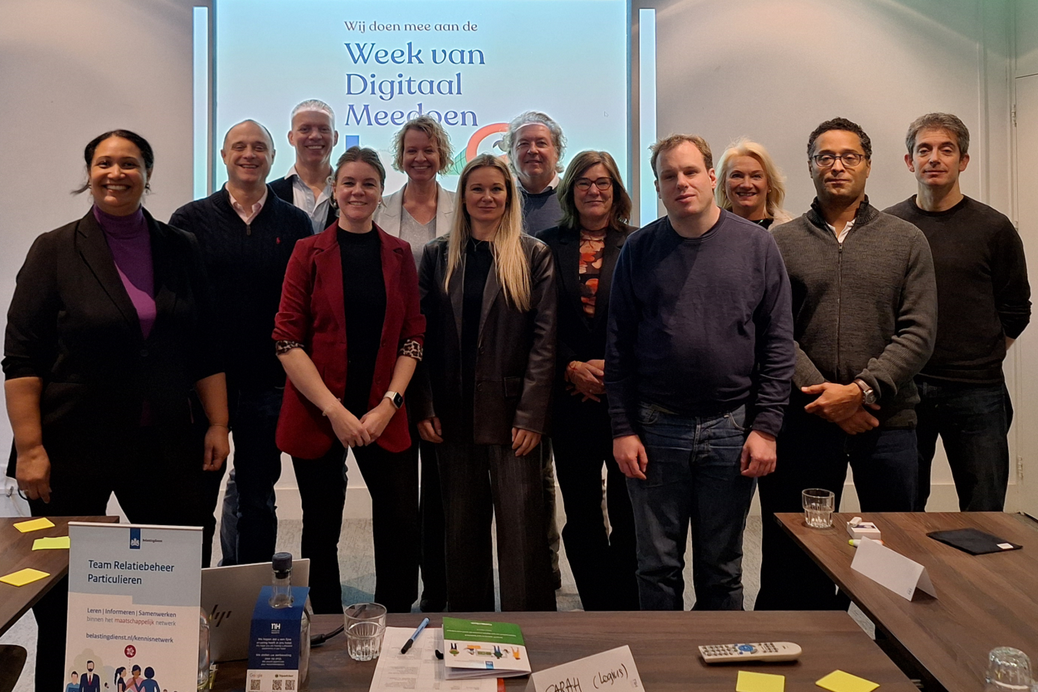 Deelnemers aan de bijeenkomst van Relatiebeheer Particulieren in het kader van de Week van Digitaal Meedoen. Van links naar rechts voorste rij: Janine Baal, Bas van Dijk, Jonne Wiessner, Virginie Veurink, Natascha Klumper, Vincent van Itallie, Jolanda Blummers, Roy Melcherts, Roeland Sorber. Van links naar rechts achterste rij: Mark Brouwer, Sarah Kanneworff, Remco Kramers