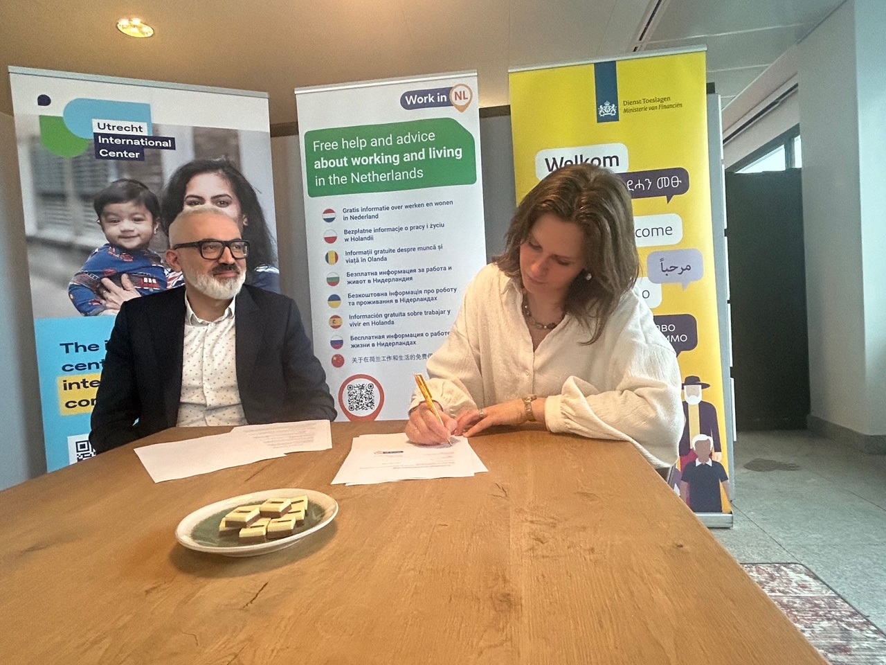 Directeur Tuncay Uyanik van het ministerie van SZW en directeur Interactie en Dienstverlening Melinda Schuurmans van Dienst Toeslagen bij het ondertekenen van de samenwerkingsovereenkomst.