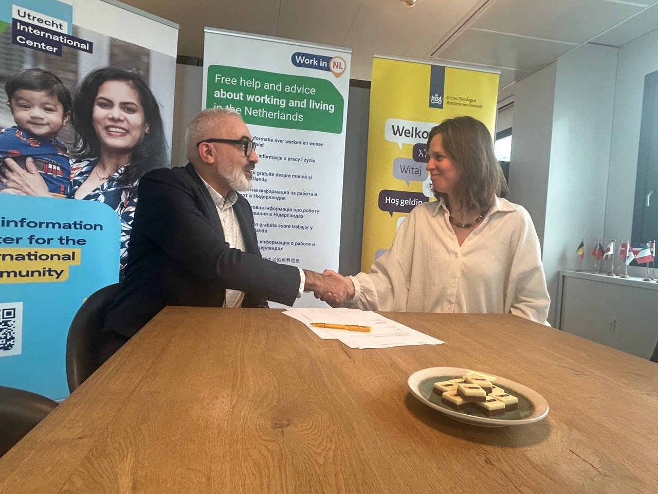 Na het ondertekenen van de samenwerkingsovereenkomst door ministerie van Sociale Zaken en Werkgelegenheid en Dienst Toeslagen een handdruk bij het WIN-punt in Utrecht.